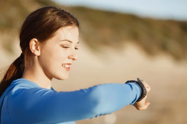 Kalp atış hızı monitörünü plajda çalışan kadınla Runner — Stok fotoğraf
