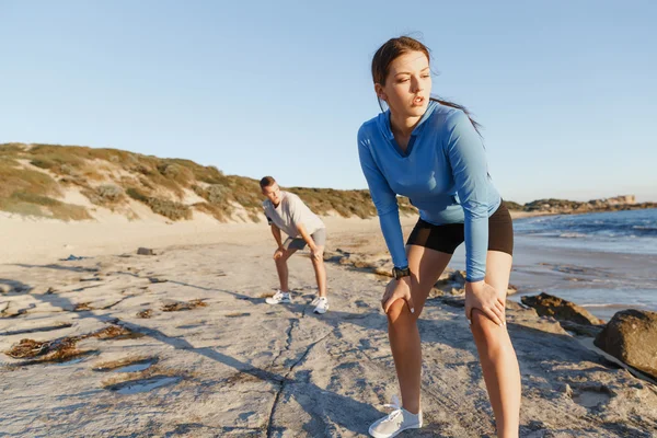 Pareja joven en el entrenamiento de playa juntos —  Fotos de Stock