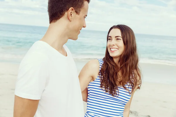 Romantische jonge paar staande op het strand — Stockfoto