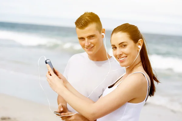 Par av löpare med smarta mobiltelefoner utomhus — Stockfoto