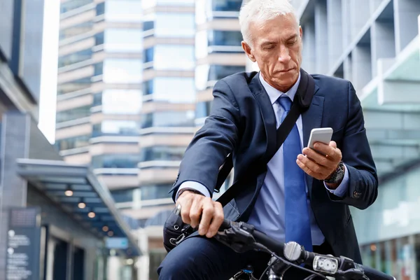 Successful businessman riding bicycle — Stock Photo, Image