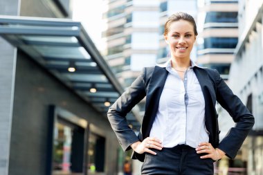 Açık havada gülümseyen bir iş kadını portresi.