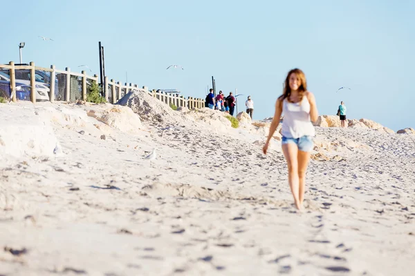 Ung kvinna vandrar längs stranden — Stockfoto