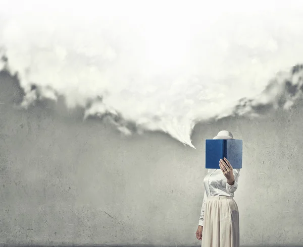 Woman hiding face behind book — Stock Photo, Image