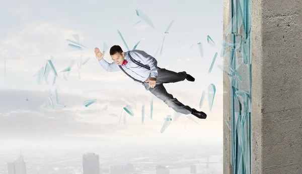 Man breaking through glass — Stock Photo, Image