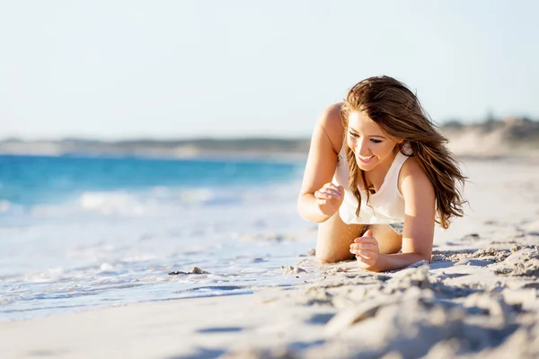 Mujer joven relajándose en la playa — Foto de Stock