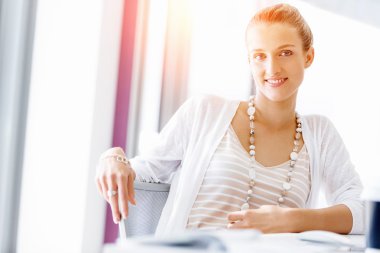 Çekici ofis çalışanı masada oturuyor.