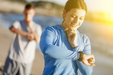 Kalp atış hızı monitörünü plajda çalışan kadınla Runner