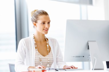 Çekici ofis çalışanı masada oturuyor.