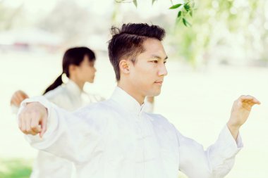 Yakışıklı adam Thai Chi yapıyor.