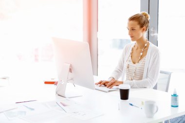 Çekici ofis çalışanı masada oturuyor.