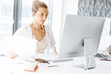 Çekici ofis çalışanı masada oturuyor.