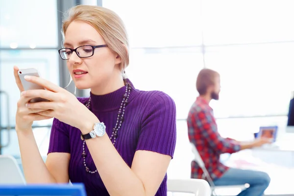 Affärskvinna i office håller mobiltelefon — Stockfoto