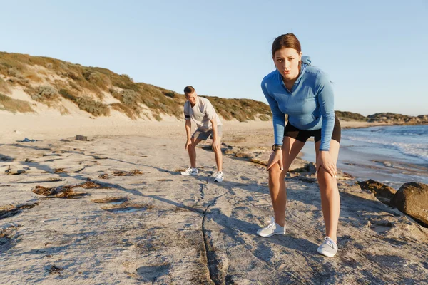 Pareja joven en el entrenamiento de playa juntos —  Fotos de Stock