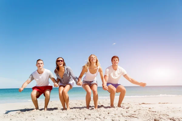 Společnost mladých lidí na pláži — Stock fotografie