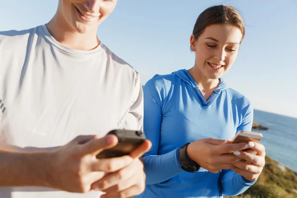Молода пара зі смартфонами на відкритому повітрі — стокове фото