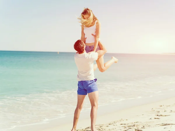 Casal feliz pulando em férias na praia — Fotografia de Stock