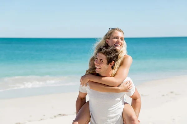 Portret van een man die een vriendin op zijn rug draagt — Stockfoto