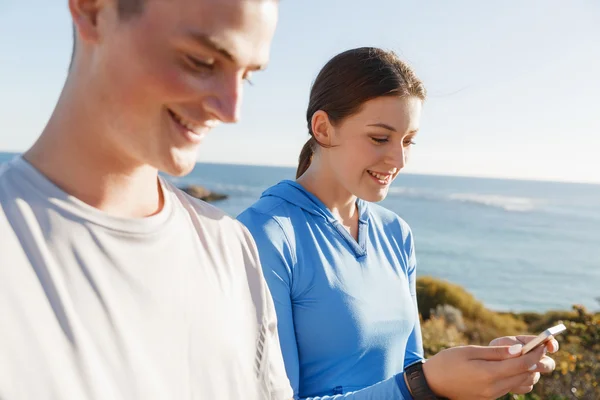 Young couple with smartphones outdoors — Stock Photo, Image