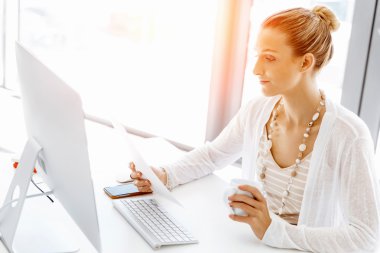 Çekici ofis çalışanı masada oturuyor.