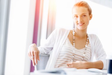 Çekici ofis çalışanı masada oturuyor.