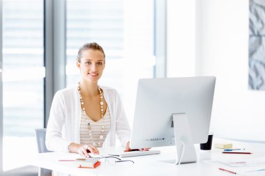Çekici ofis çalışanı masada oturuyor.