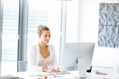 Çekici ofis çalışanı masada oturuyor.