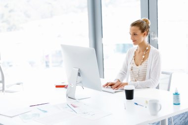 Çekici ofis çalışanı masada oturuyor.