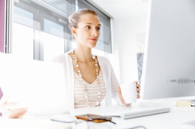 Çekici ofis çalışanı masada oturuyor.
