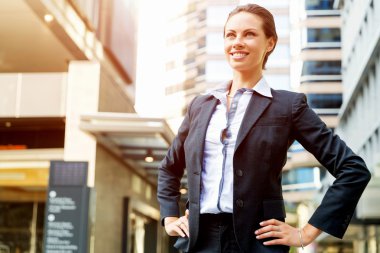 Açık havada gülümseyen bir iş kadını portresi.