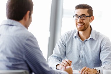 Ofiste iki yakışıklı işadamı var.