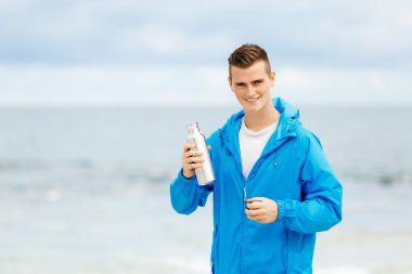 Şişe su ile tutarak kendine güvenen genç adam