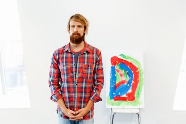 Bir resim ile ayakta genç erkek sanatçı