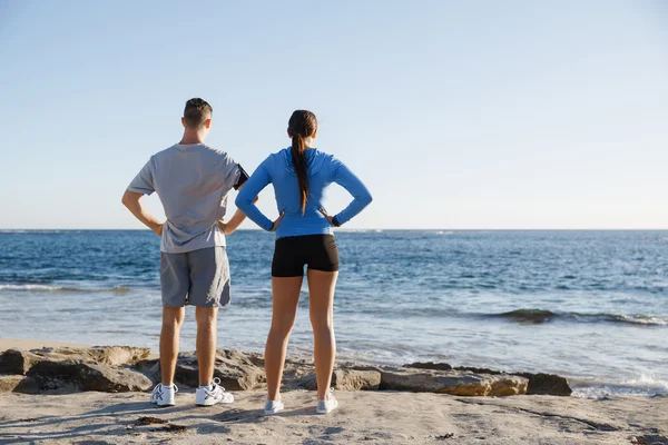 Jong (echt) paar op het strand training samen — Stockfoto