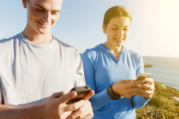 Jeune couple avec smartphones en plein air — Photo