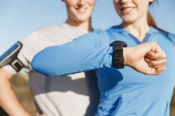 Runner donna con cardiofrequenzimetro in esecuzione sulla spiaggia — Foto Stock