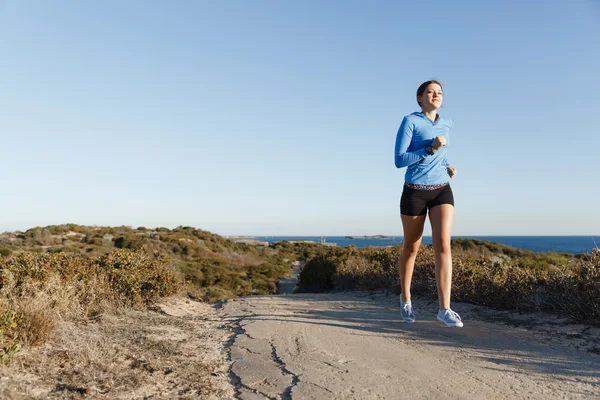 Sport runner joggen op strand uit te werken — Stockfoto