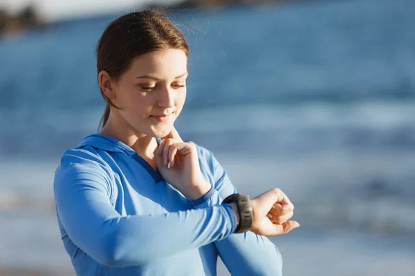 Loper vrouw met hartslagmeter uitgevoerd op strand — Stockfoto