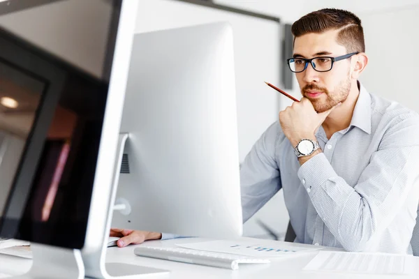 Männliche Büroangestellte sitzt am Schreibtisch — Stockfoto