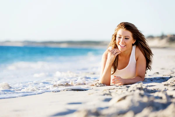 Junge Frau entspannt am Strand — Stockfoto