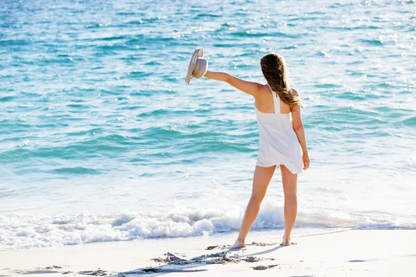 Junge Frau läuft am Strand entlang — Stockfoto