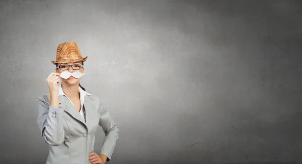 Businesswoman trying paper mustache — Stock Photo, Image