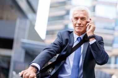 Cep telefonu ile bisiklet üzerinde başarılı iş adamı