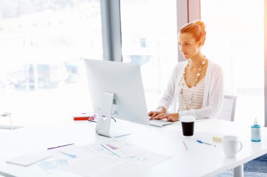 Çekici ofis çalışanı masada oturuyor.