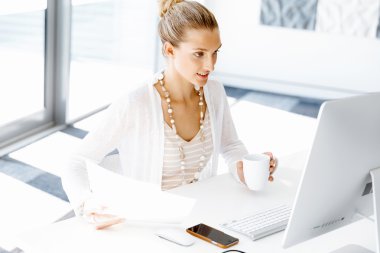 Çekici ofis çalışanı masada oturuyor.