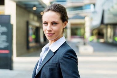 Açık havada gülümseyen bir iş kadını portresi.