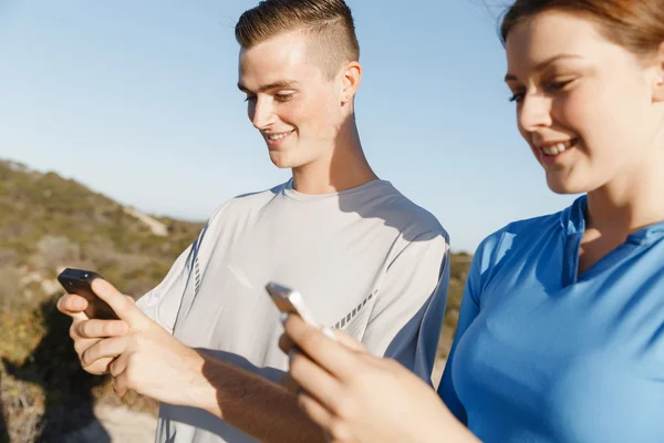 Jong (echt) paar met smartphones outdoors — Stockfoto