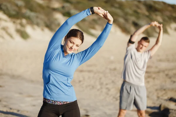 Молода пара на пляжі тренується разом — стокове фото