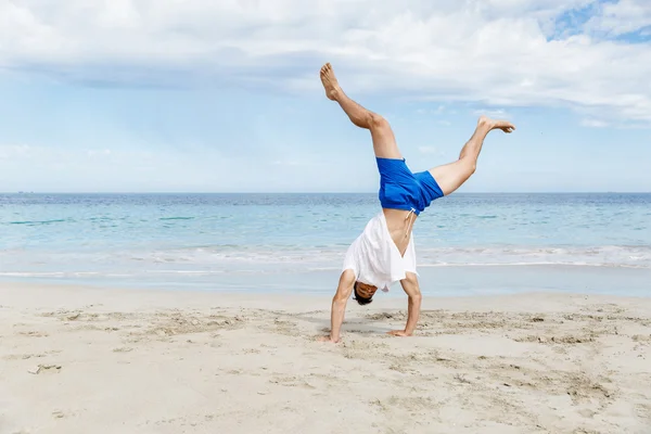 Jeune homme sautant sur la plage — Photo