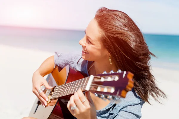 Bella giovane donna che suona la chitarra sulla spiaggia — Foto Stock